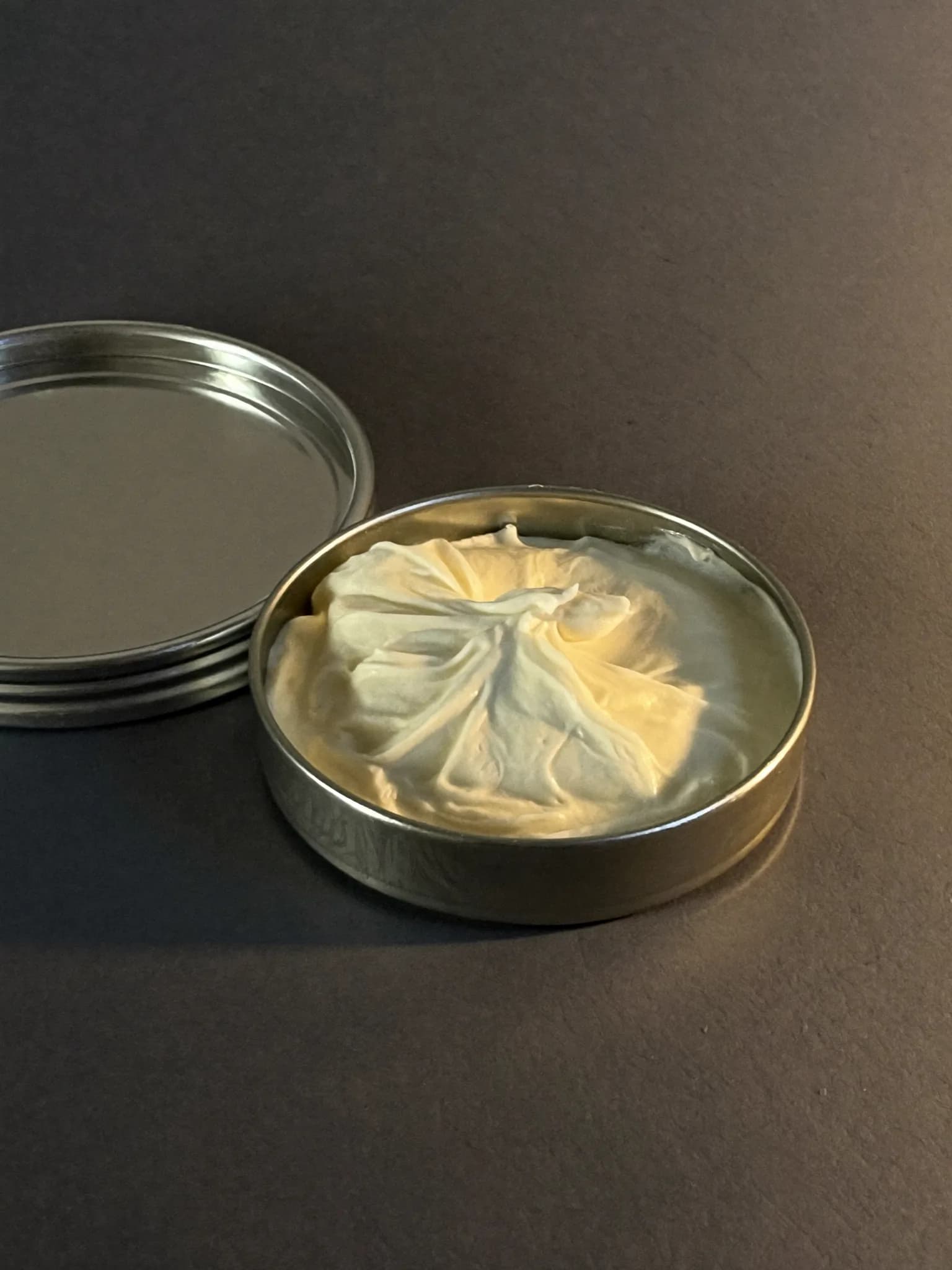 An open tin of whipped body butter with soft peaks